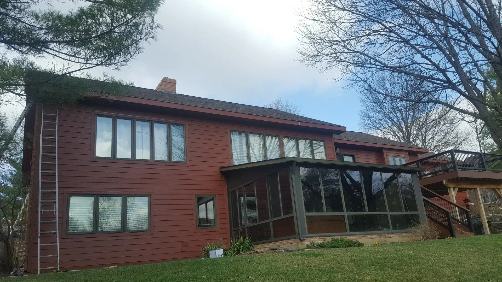 A large red brick house with a screened in porch and stairs.