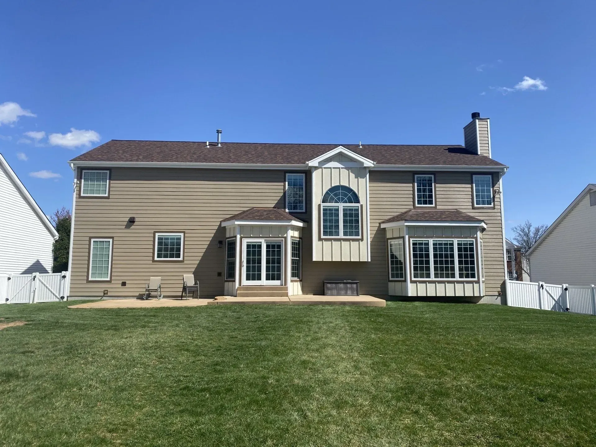 The back of a house with a large lawn in front of it