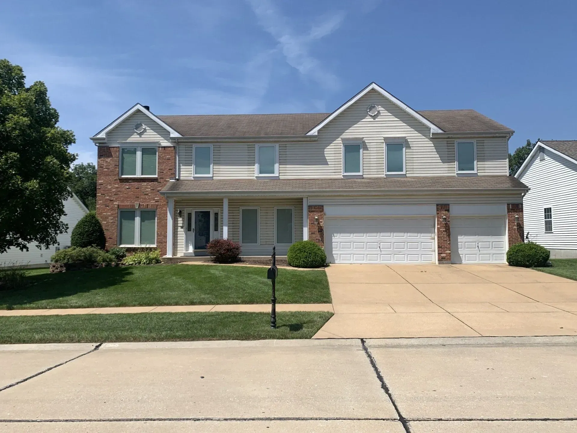 A large house with a lot of windows and a driveway