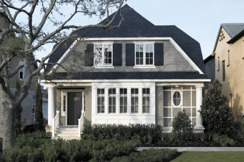 A white house with a black roof and black shutters