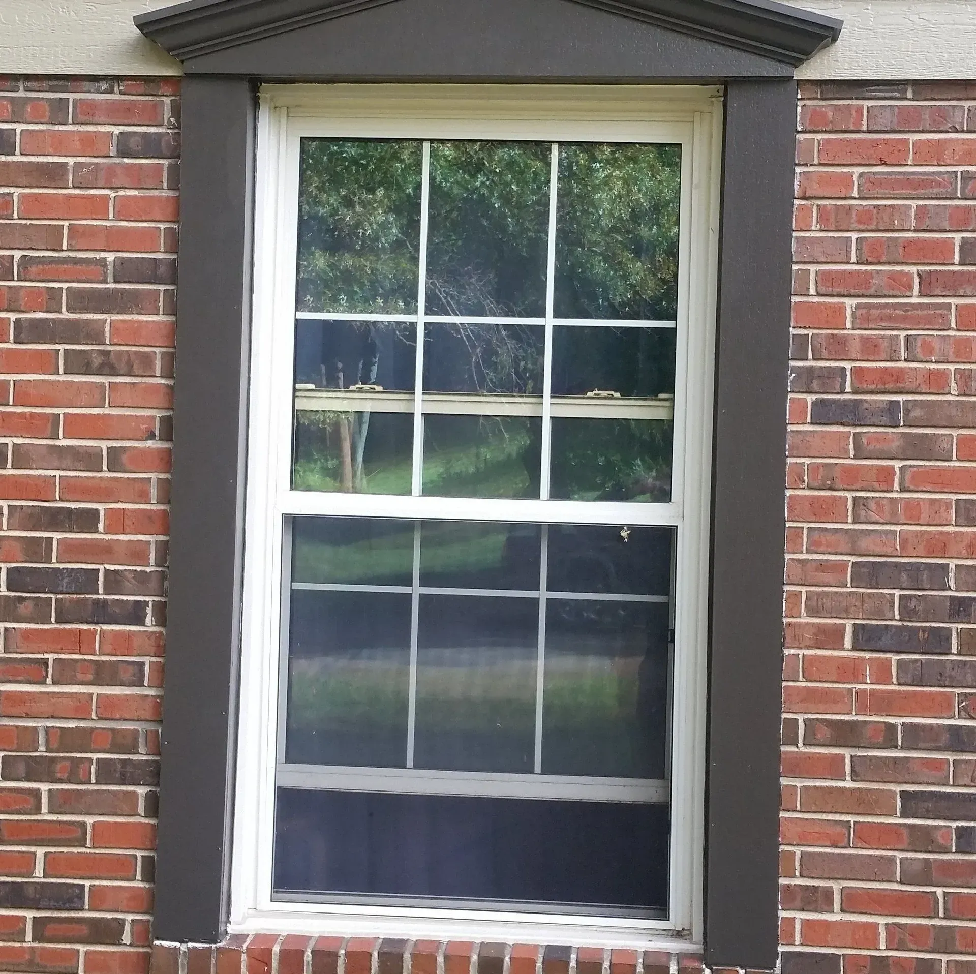 A window on a brick building with a white frame