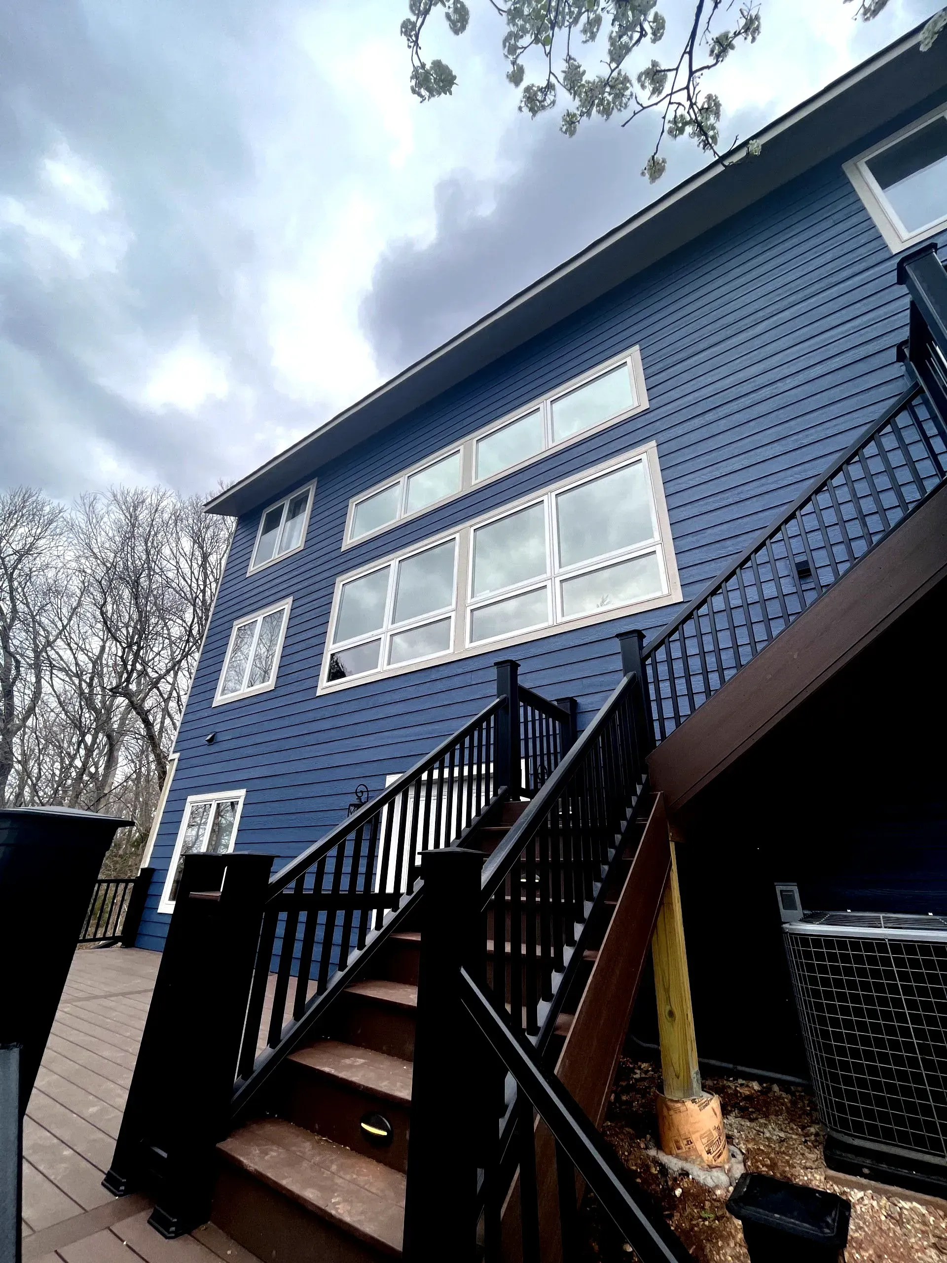 A blue house with stairs leading up to the second floor.