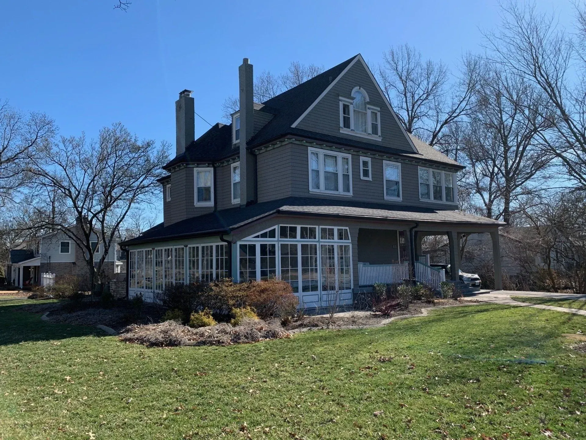 A large house with a lot of windows and a large lawn in front of it.