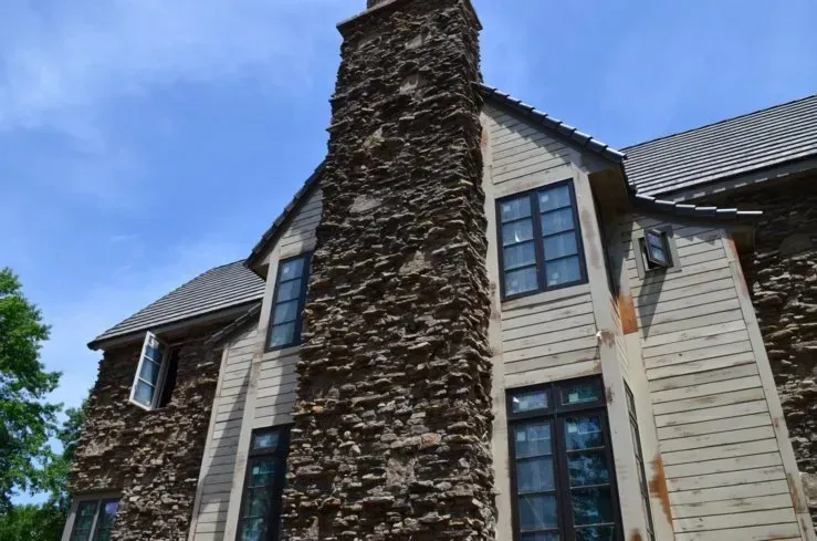 A large house with a chimney on the side of it