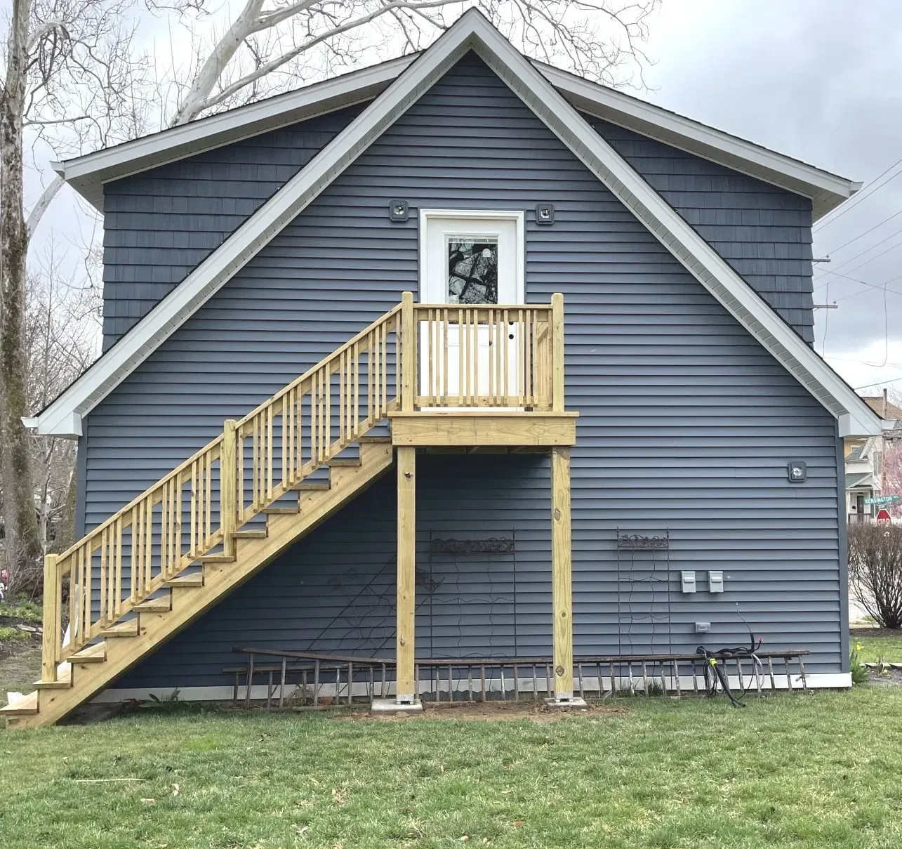 A blue house with a wooden deck and stairs
