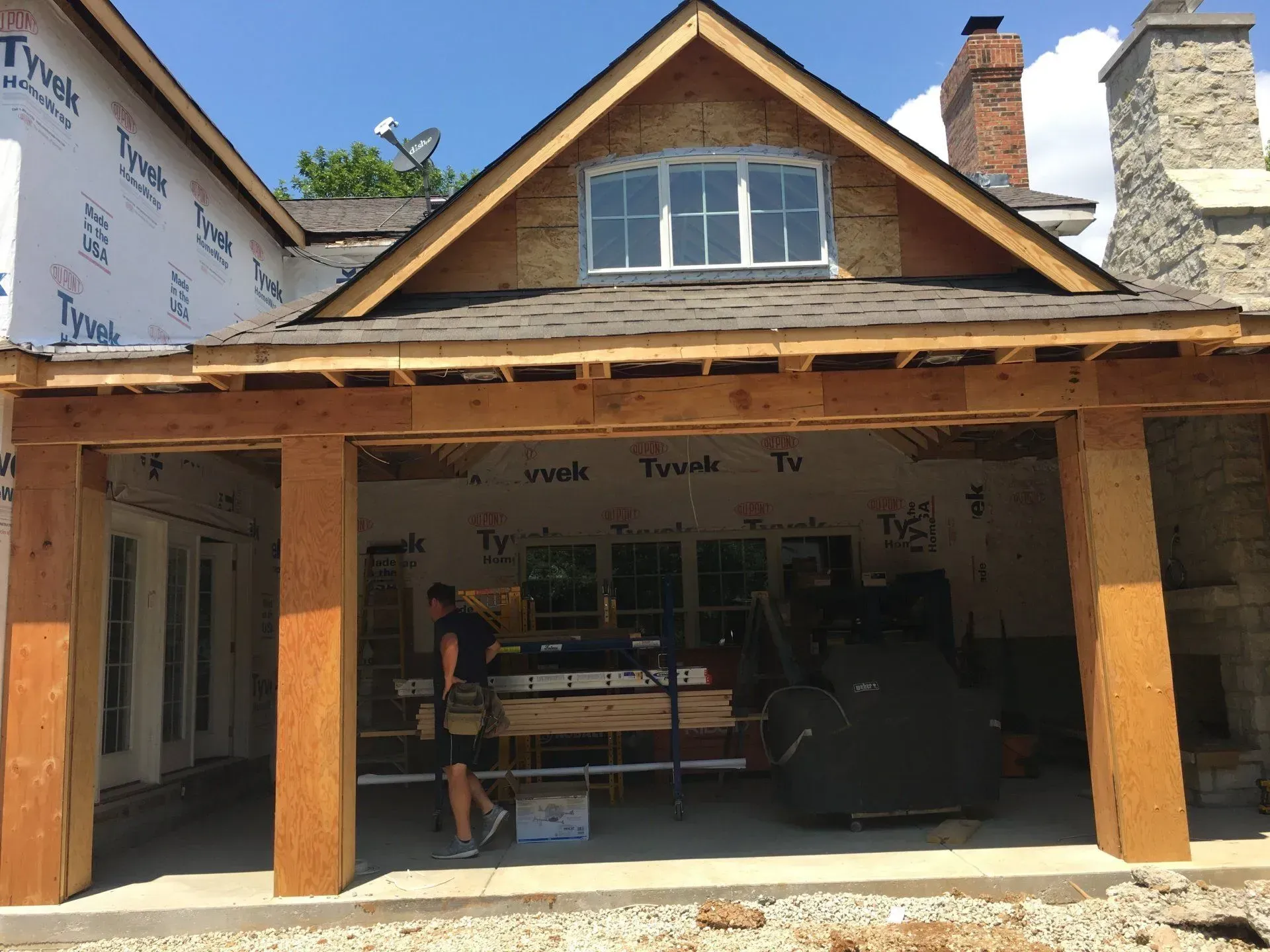A man is standing in front of a house that is being built
