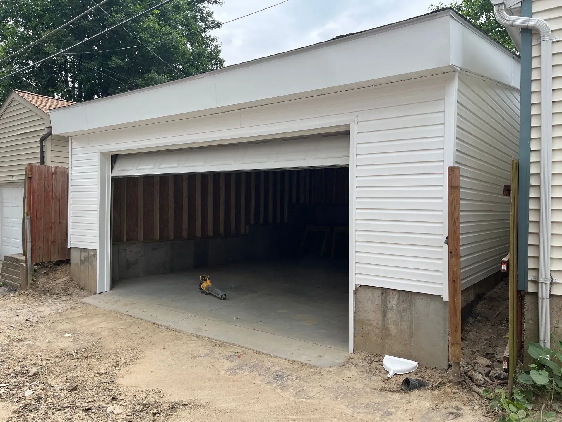 A garage is being built in the backyard of a house.