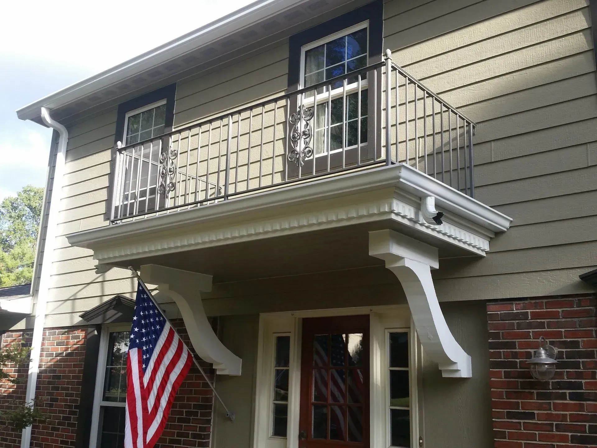 A house with a balcony and an american flag