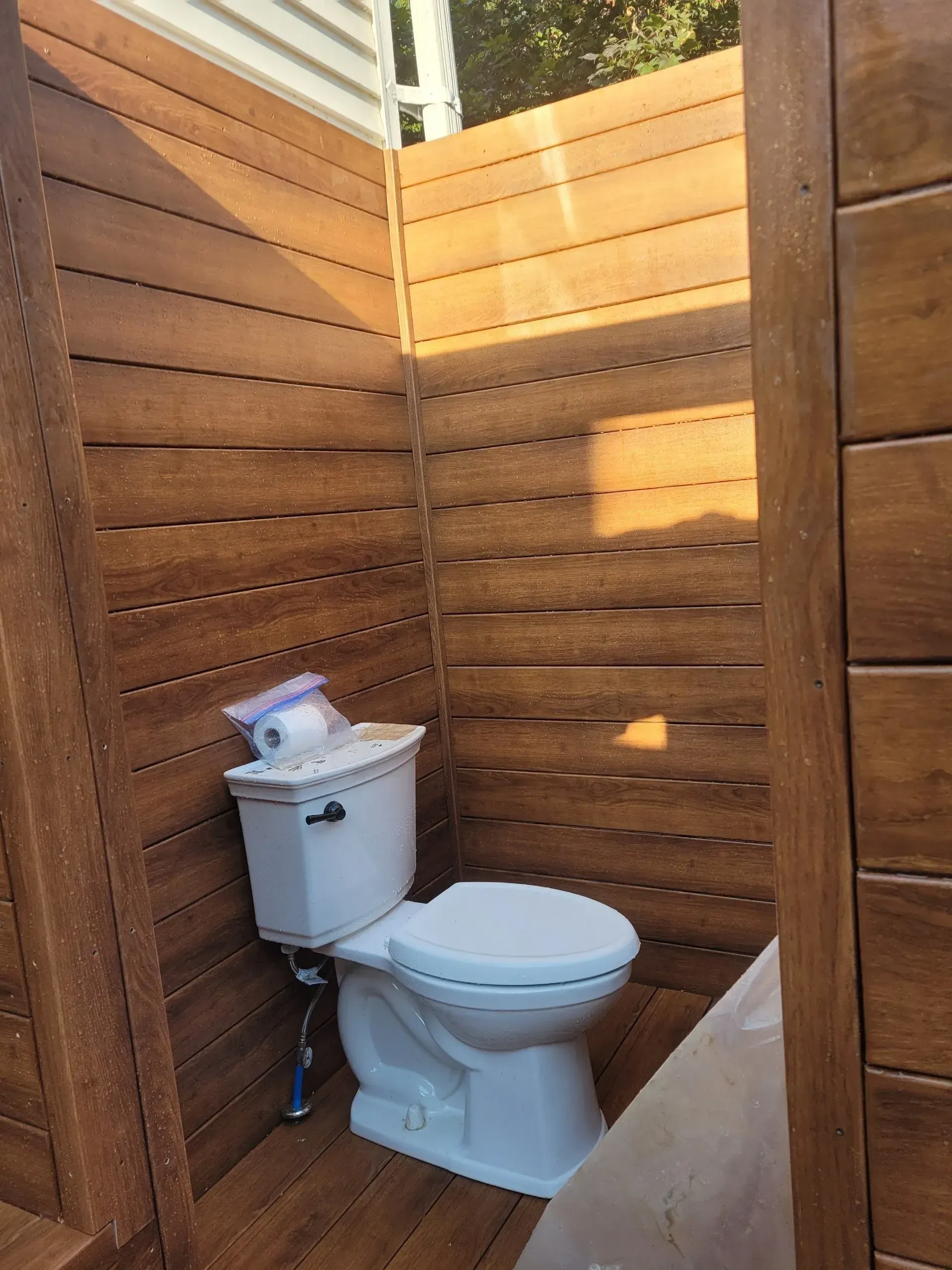 A bathroom with a toilet and a wooden wall