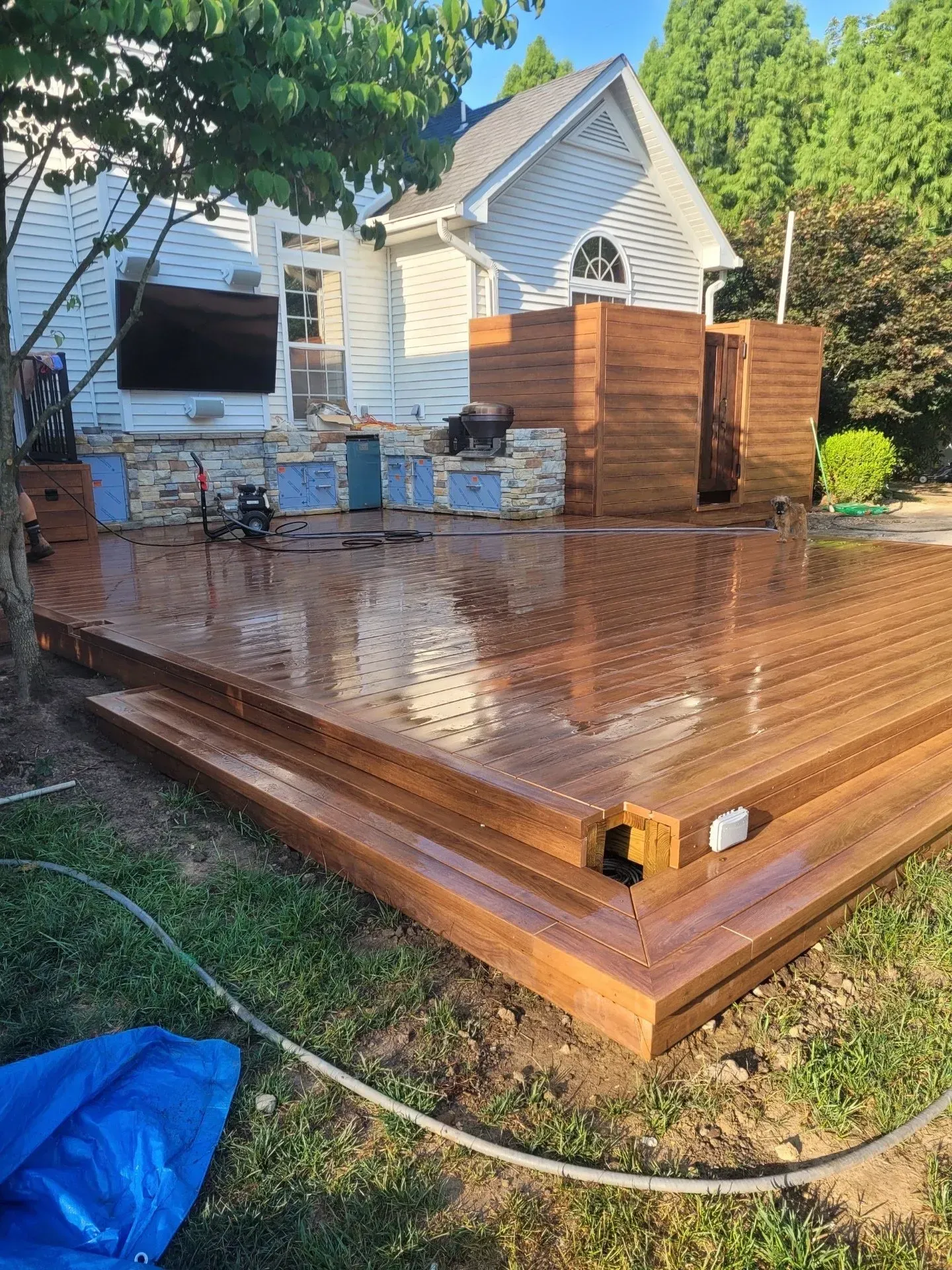 A wooden deck is being built in the backyard of a house.