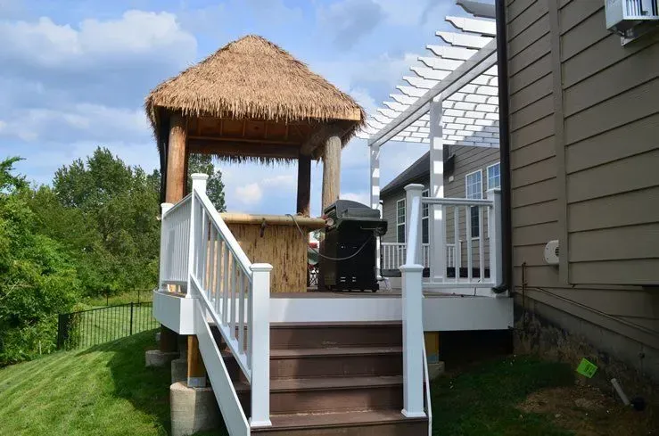 A deck with a gazebo and a grill on it