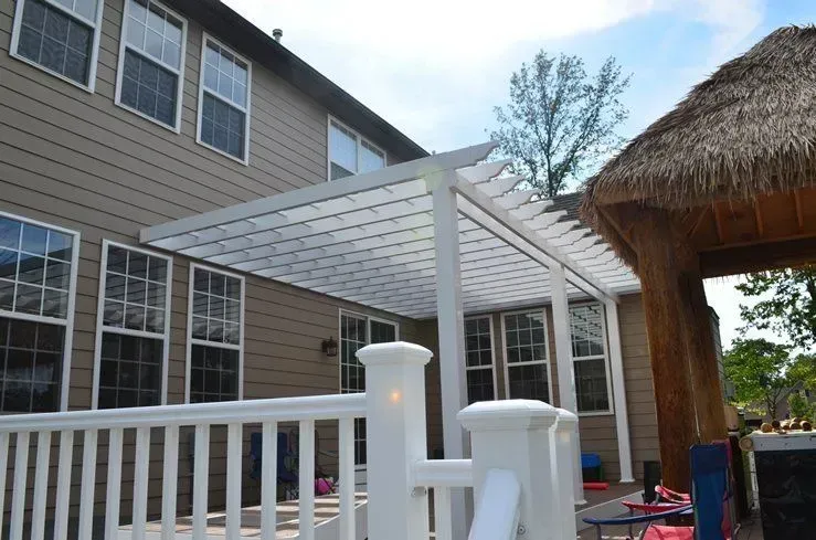 A deck with a pergola and a thatched roof