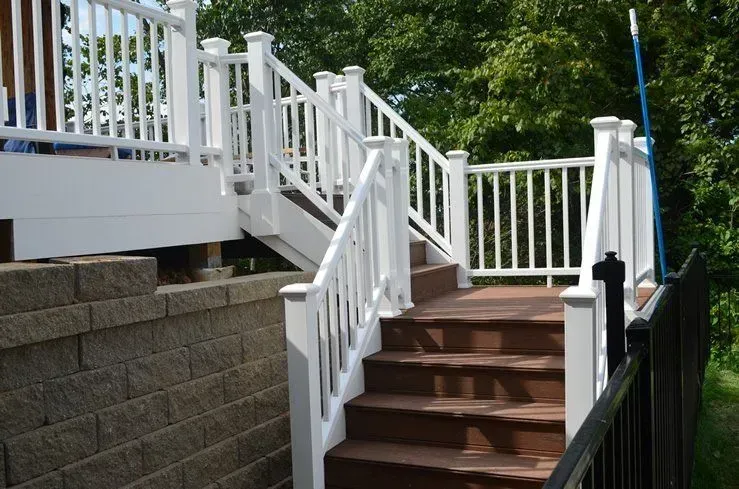 Stairs leading up to a deck with a white railing