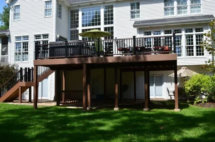 A large white house with a large deck in front of it.