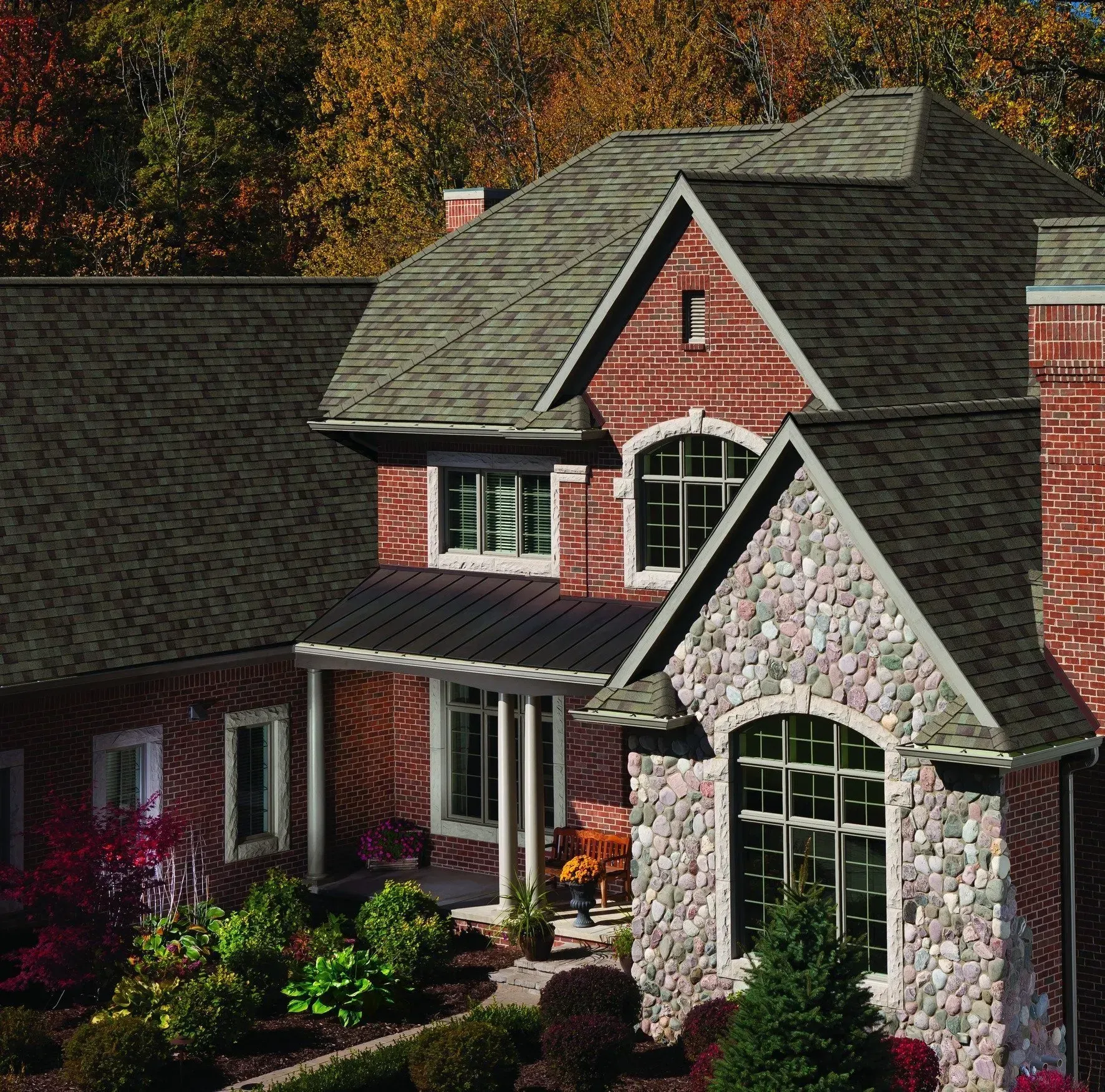 A large brick and stone house with a gray roof