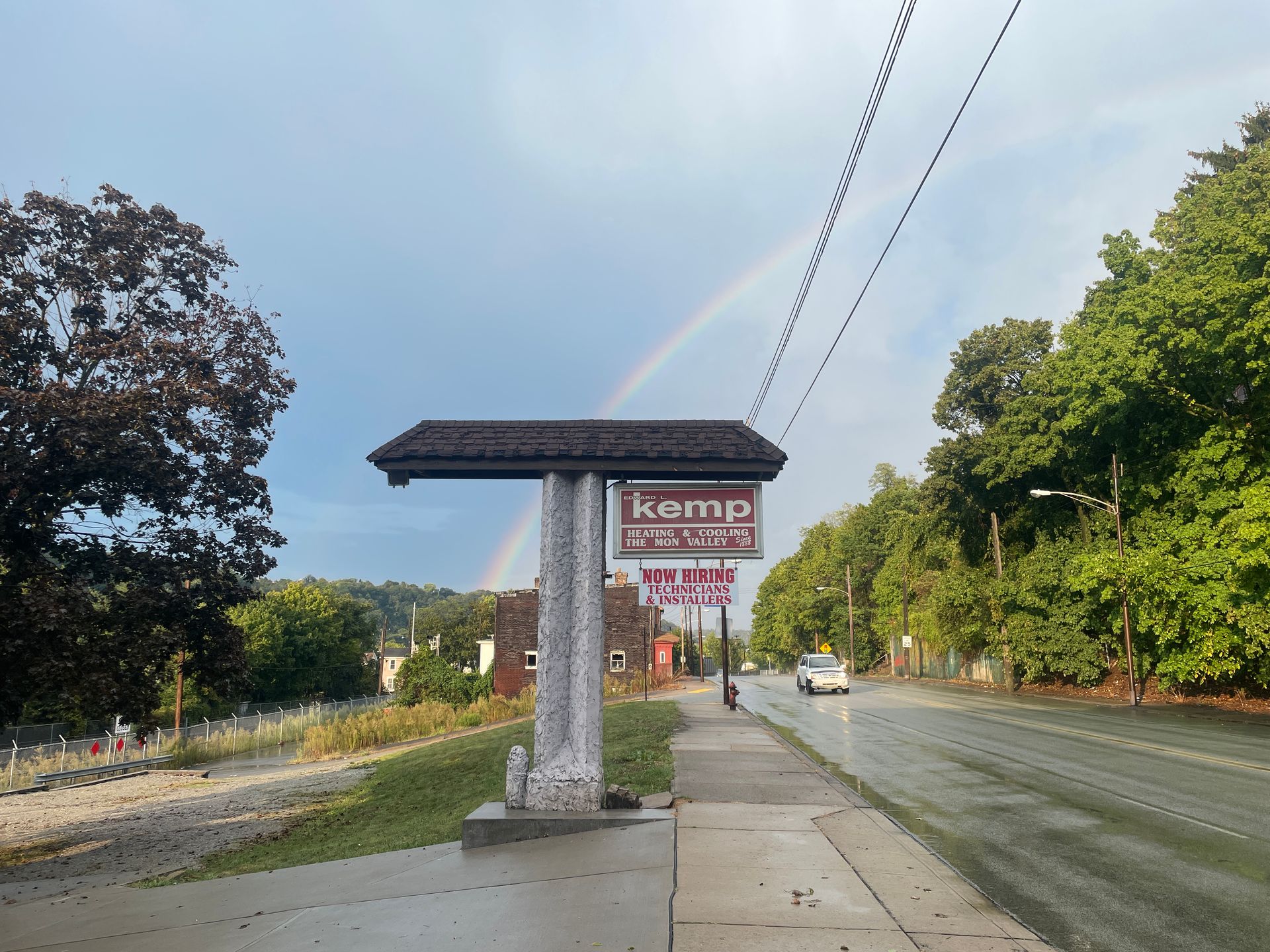 Rainbow arcs over a roadside sign for 