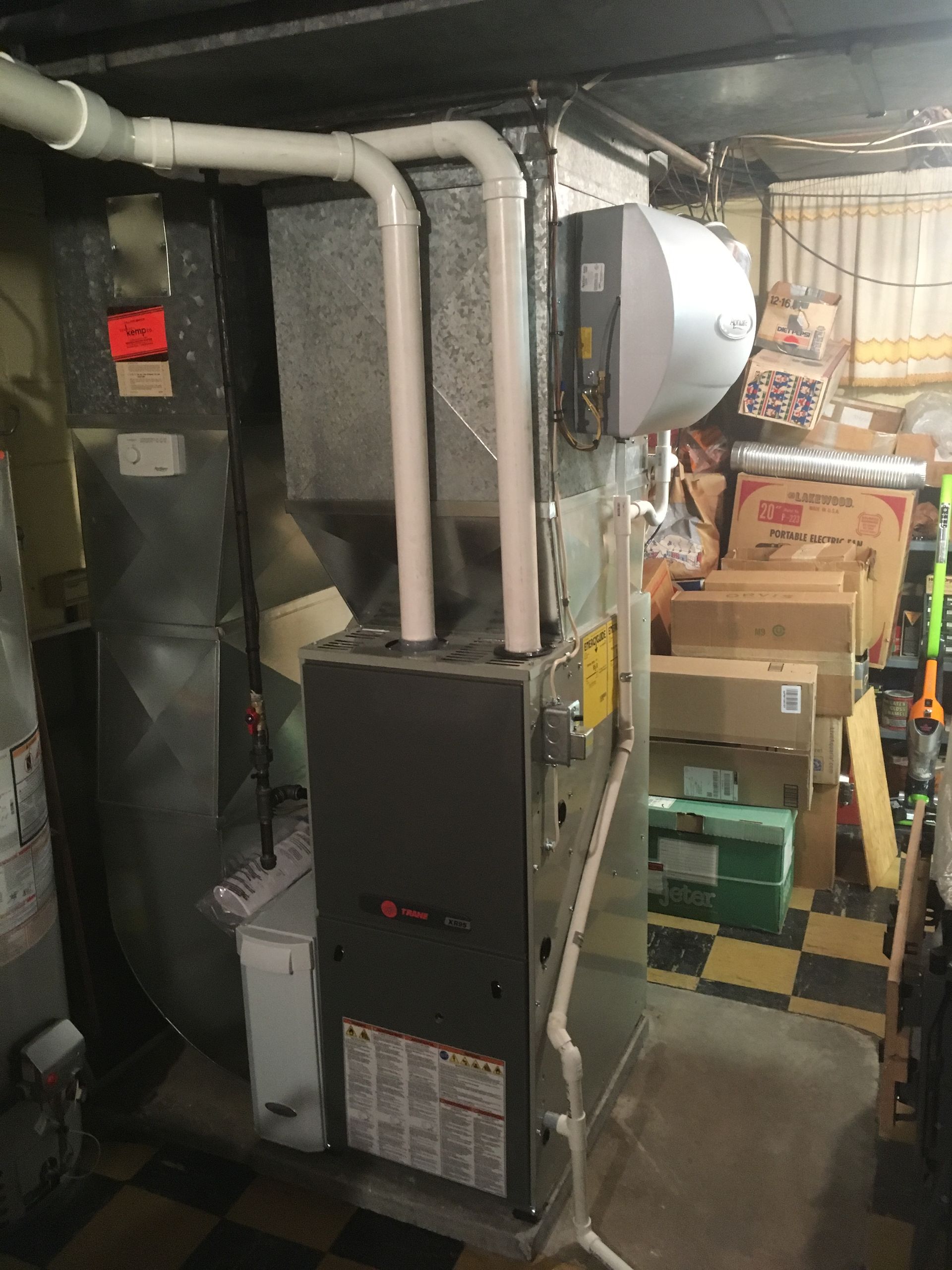 Furnace with attached humidifier, ductwork, in a basement setting.