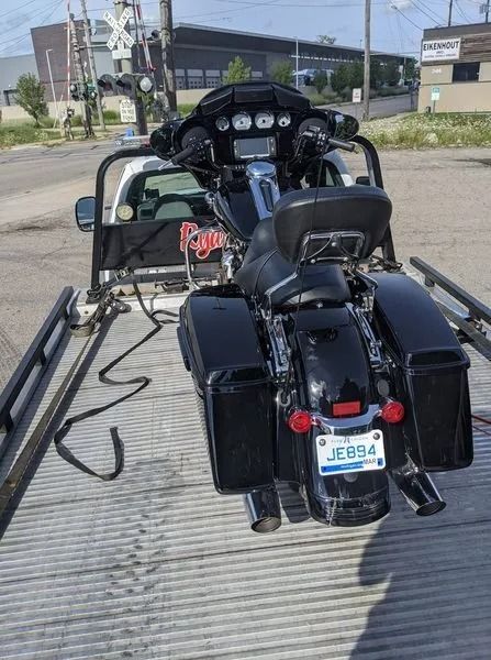 Black motorcycle with sidecar on a ramp, parked outdoors near buildings.