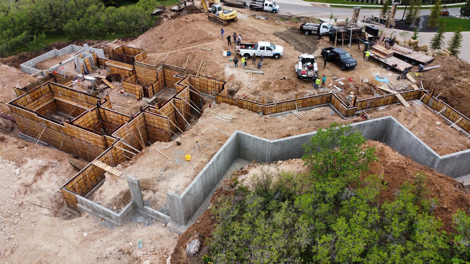 An aerial view of a construction site with trucks parked in the dirt