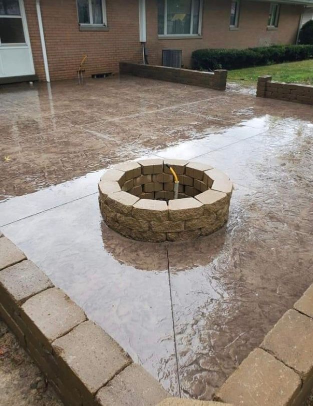 A fire pit is sitting on top of a concrete patio.