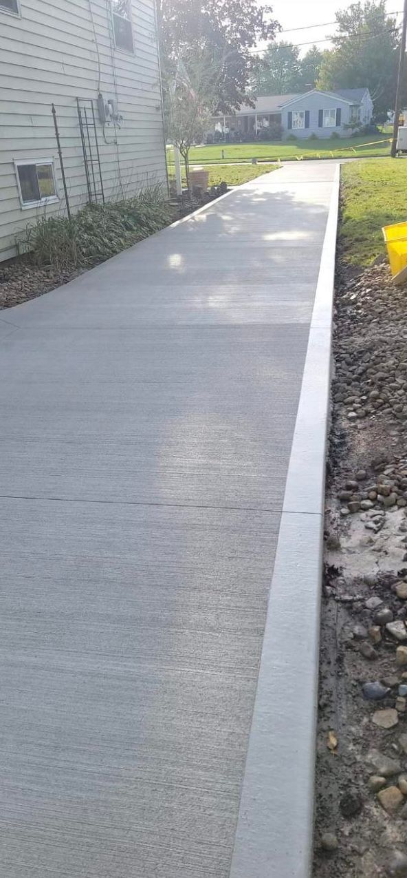 A concrete walkway is being built in front of a house.