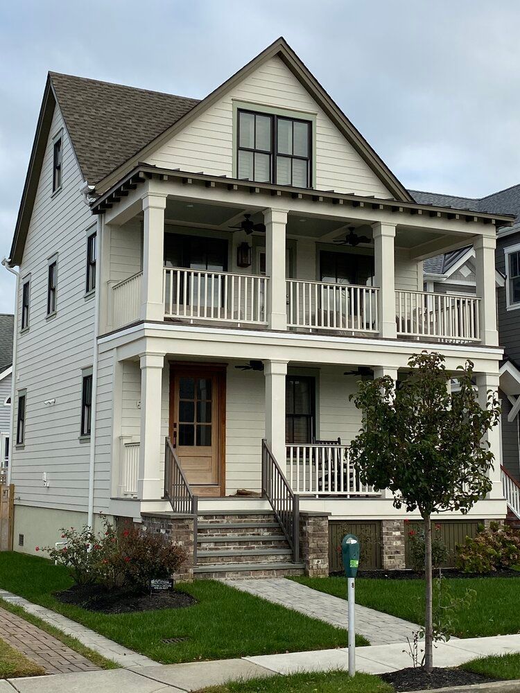 A large white house with a porch and stairs