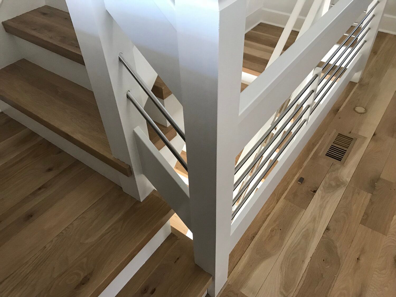 A staircase with wooden steps and a white railing