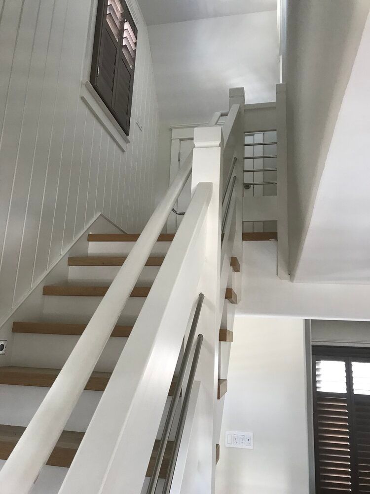 A white staircase with wooden steps and a white railing
