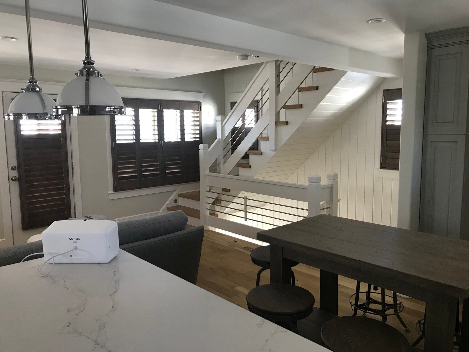 A kitchen with a table and stairs in the background