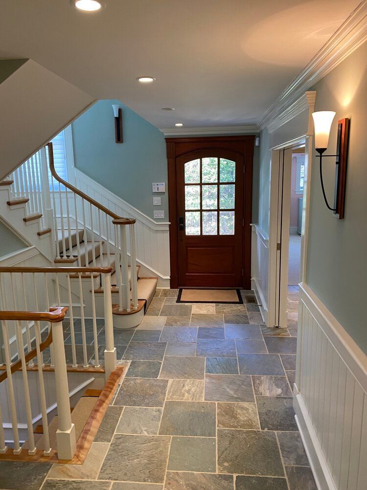 A hallway with stairs and a wooden door