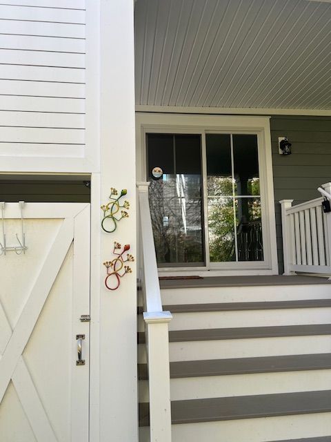 A white house with a sliding glass door and stairs