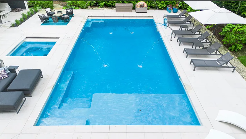 Luxury pool with blue water, white deck, lounge chairs, and shaded seating area