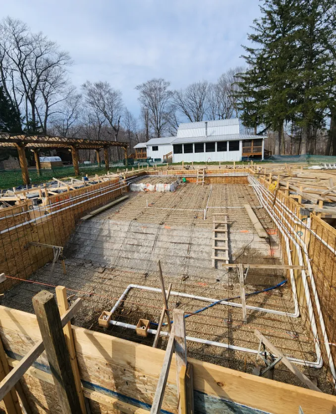 Concrete foundation excavation with rebar and wood forms at a residential construction site