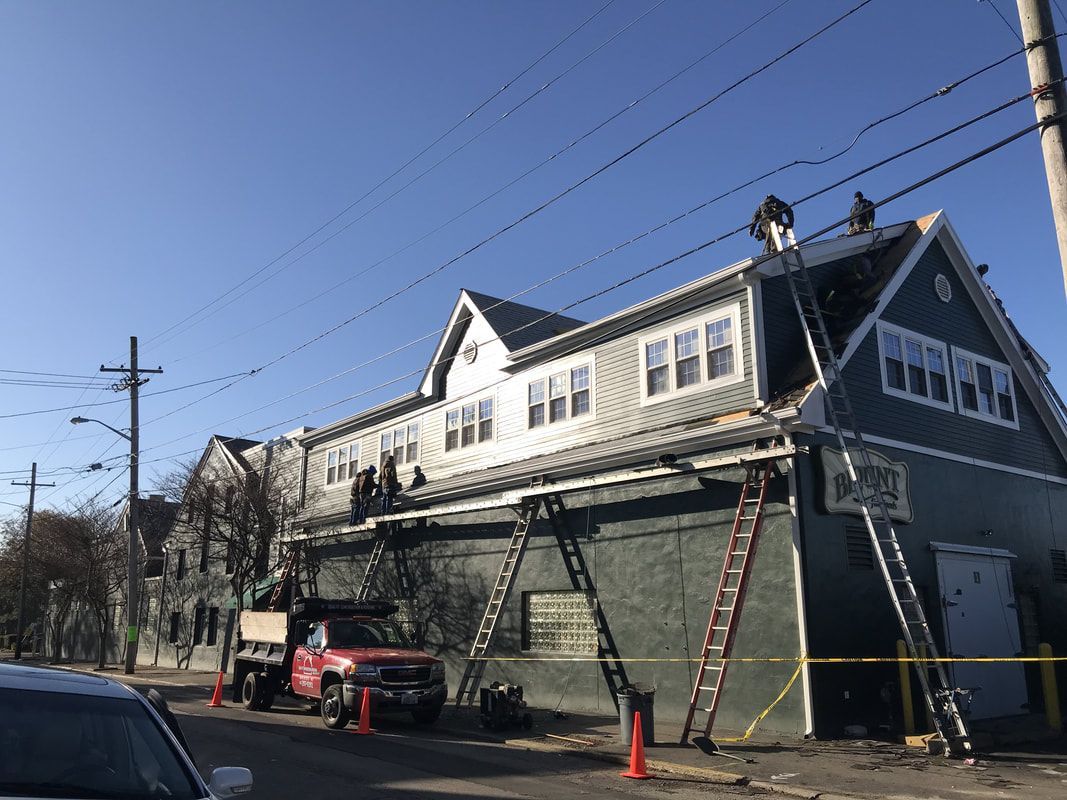A group of people are working on the roof of a building.
