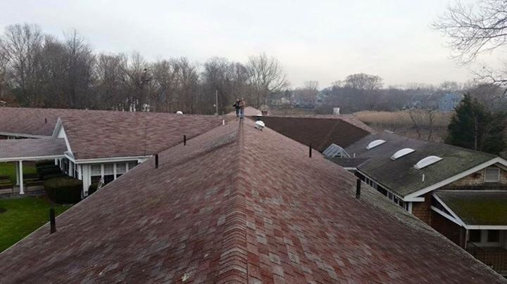 A man is standing on the roof of a house.