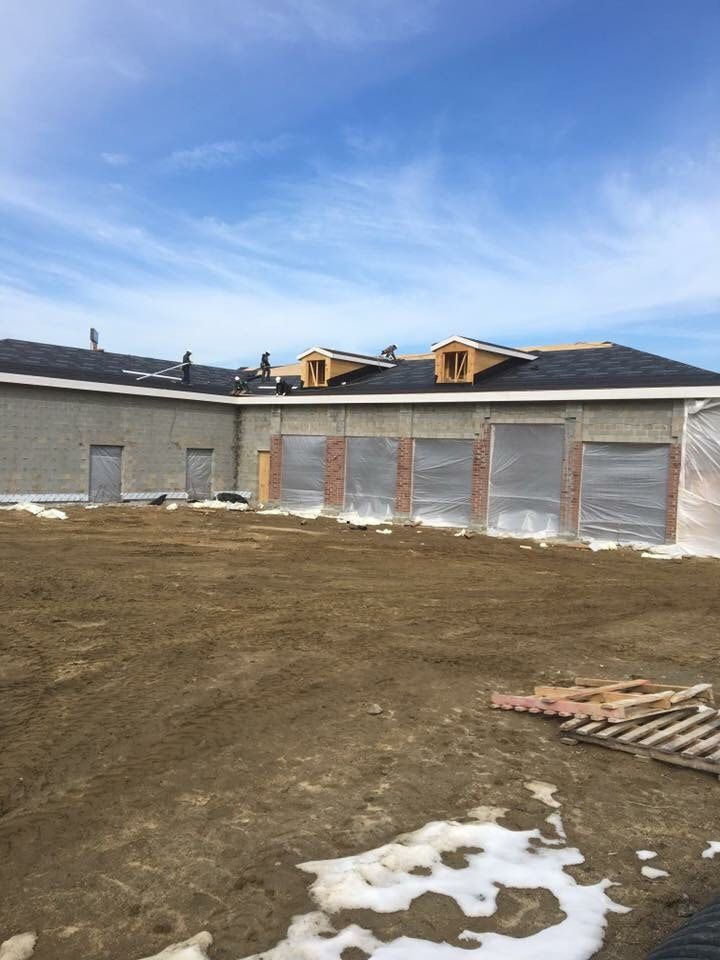 A large building under construction with a lot of dirt in front of it.