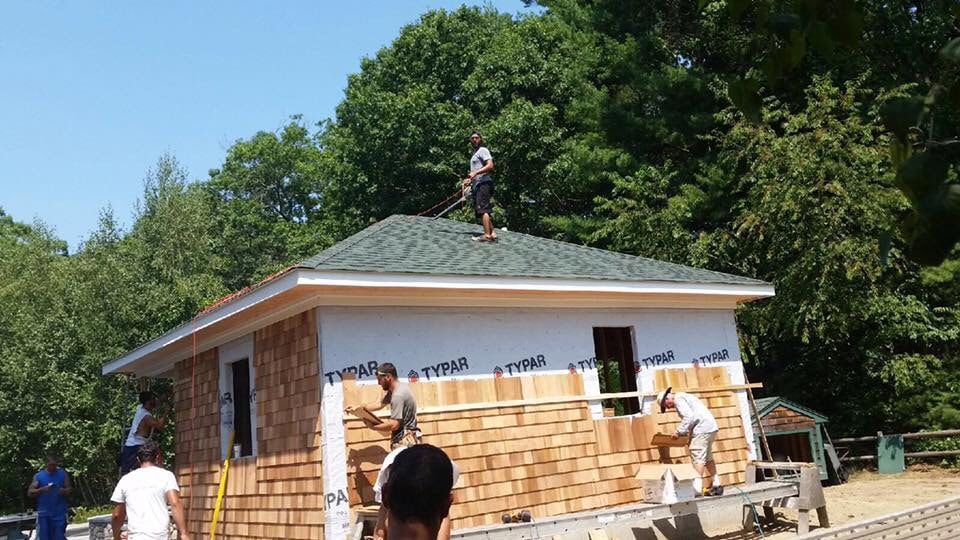 A group of people are working on a house.