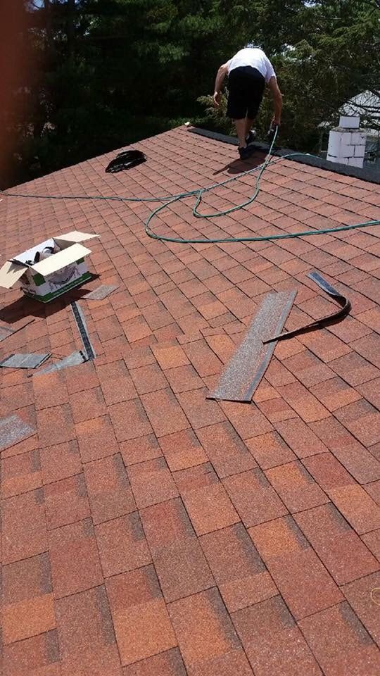 A man is working on the roof of a house.