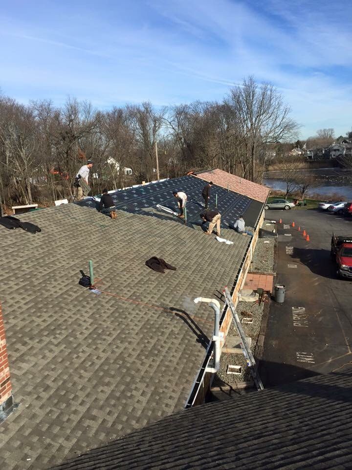 A group of people are working on the roof of a building.