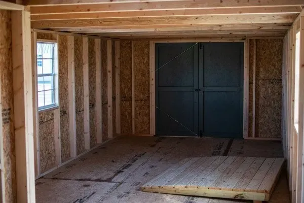 A wooden room with a blue door and a window.