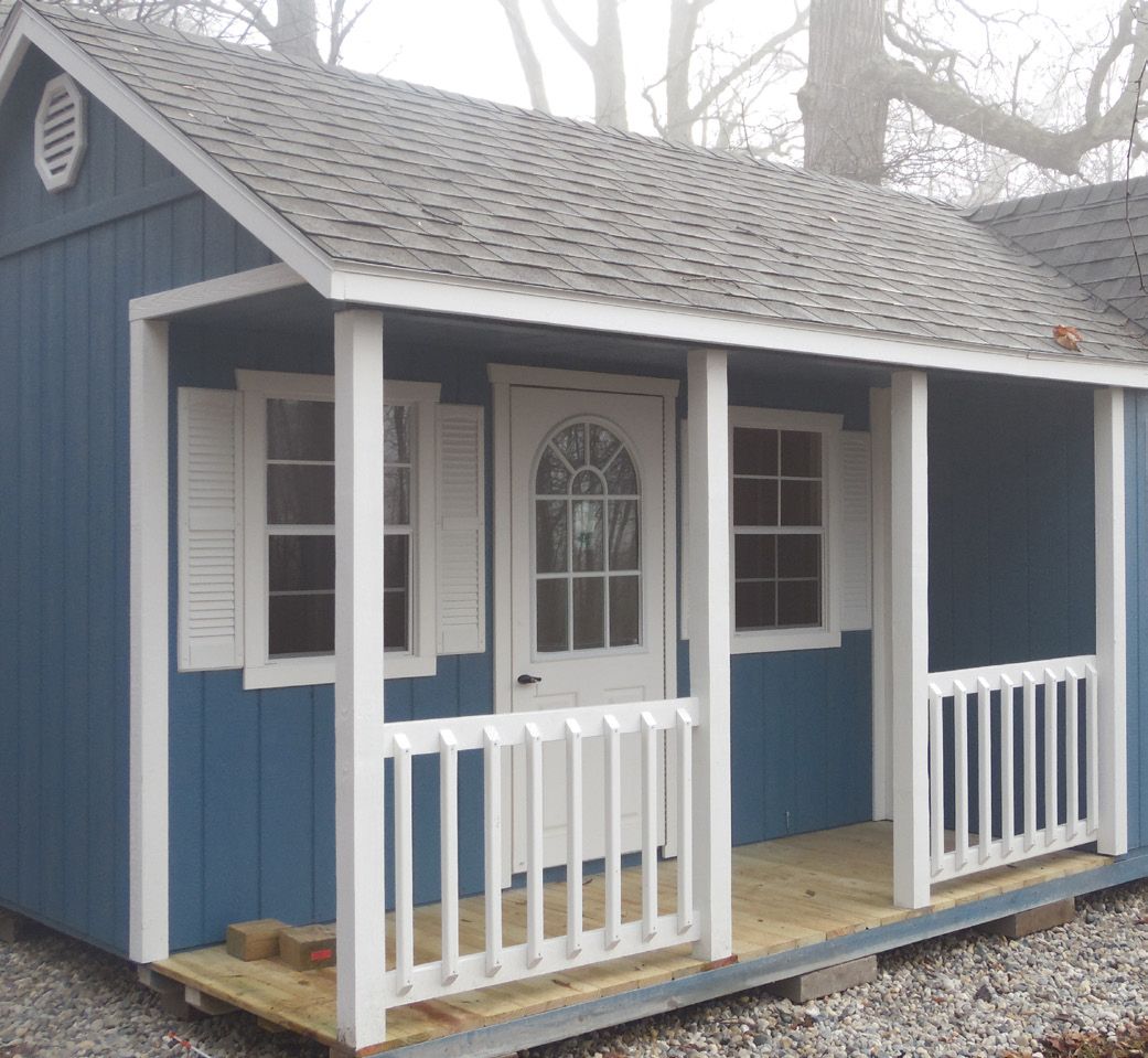 A small blue house with a porch and shutters