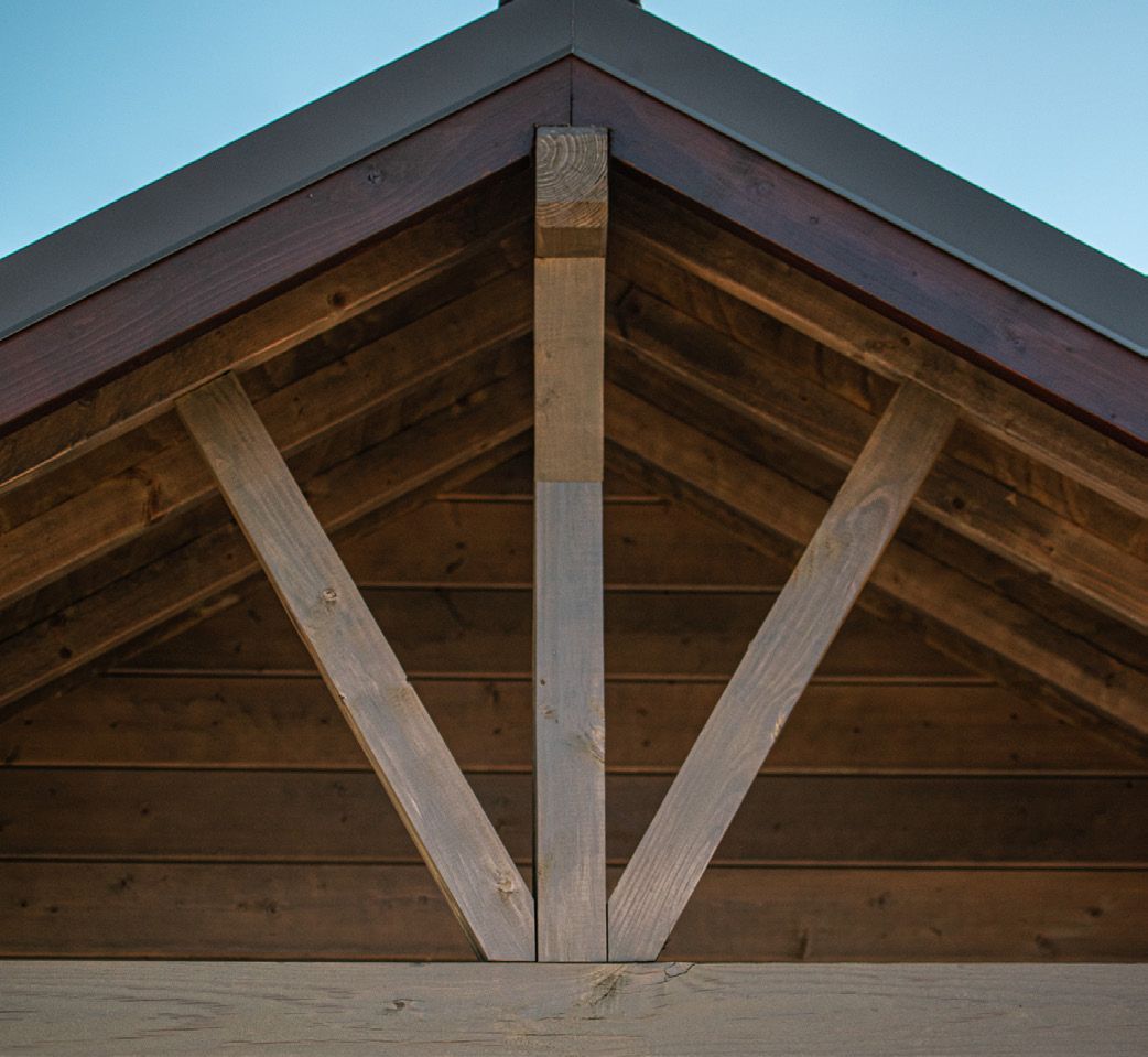 A close up of a wooden roof with a blue sky in the background