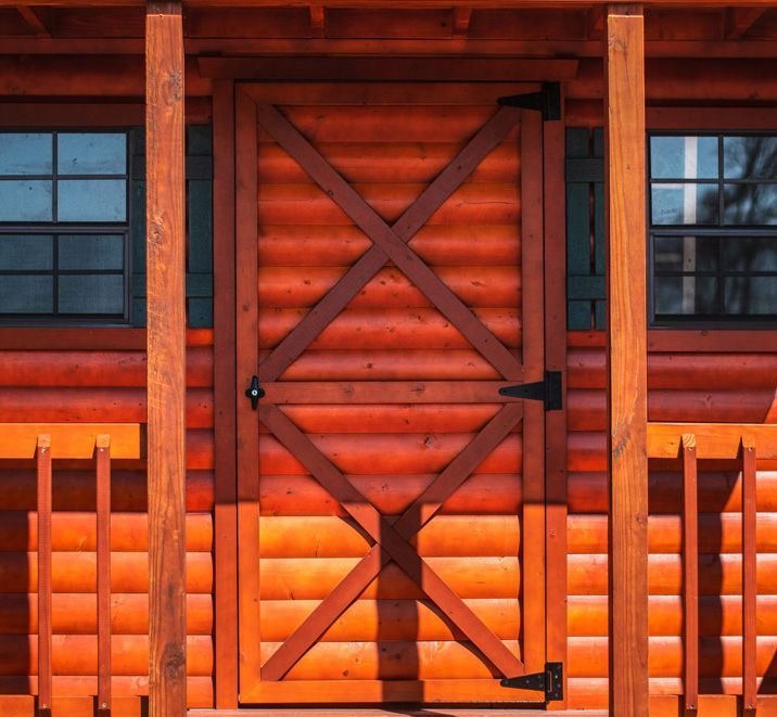 A wooden door on the front of a log cabin.