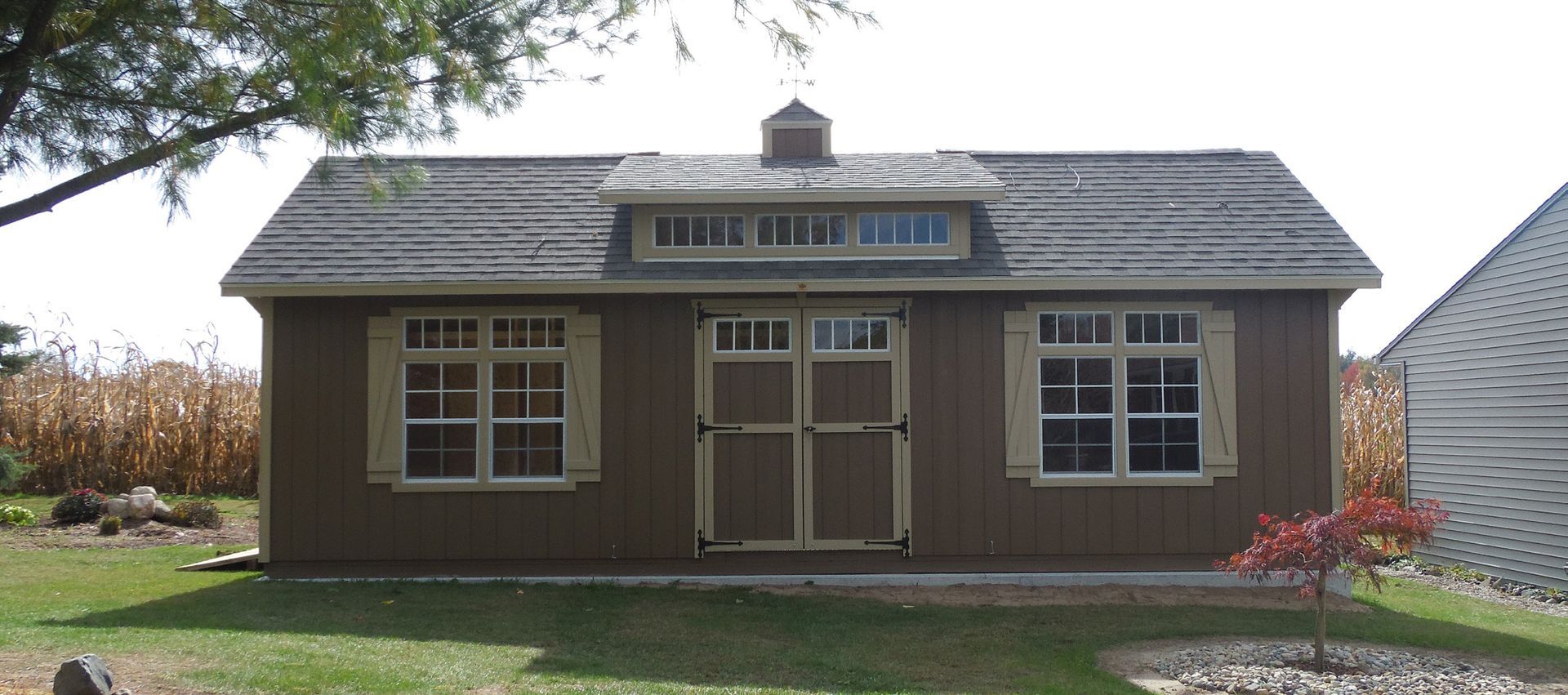 A small brown house with a roof that has a skylight