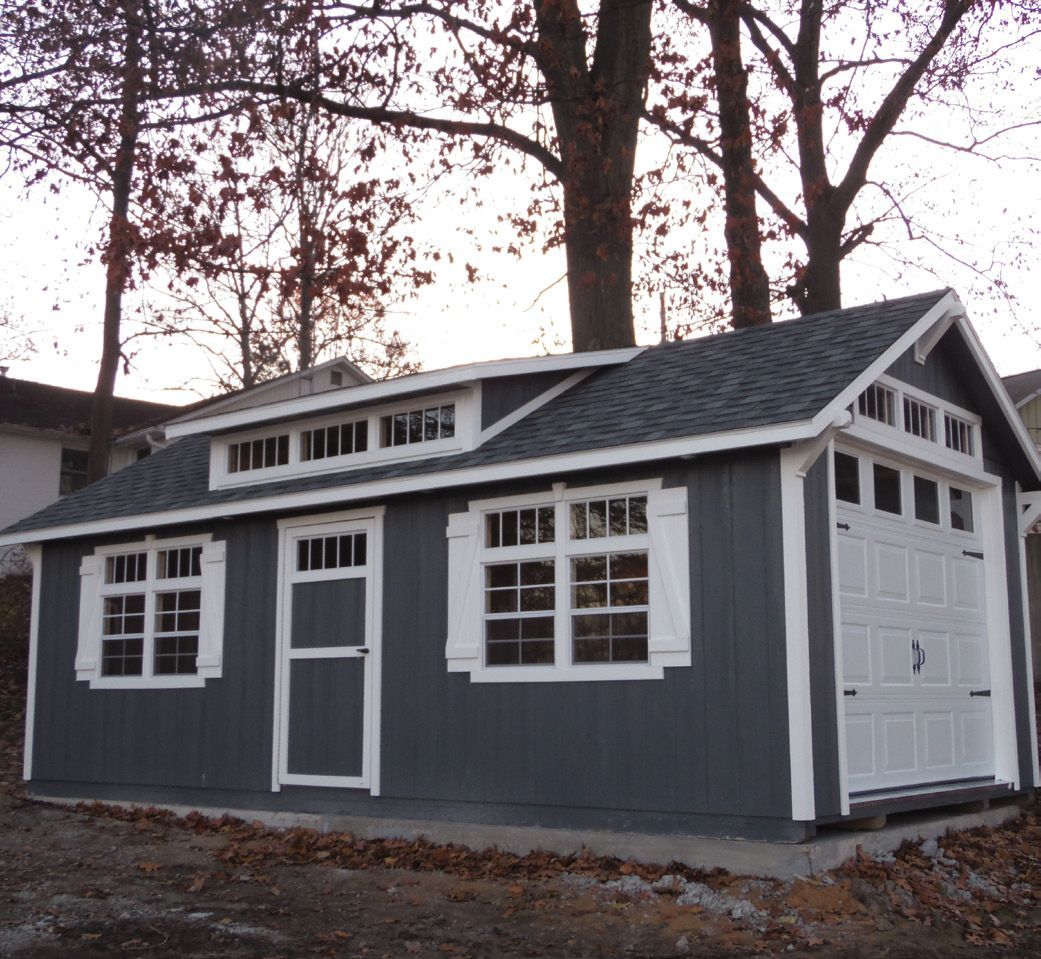 A gray garage with white trim and windows