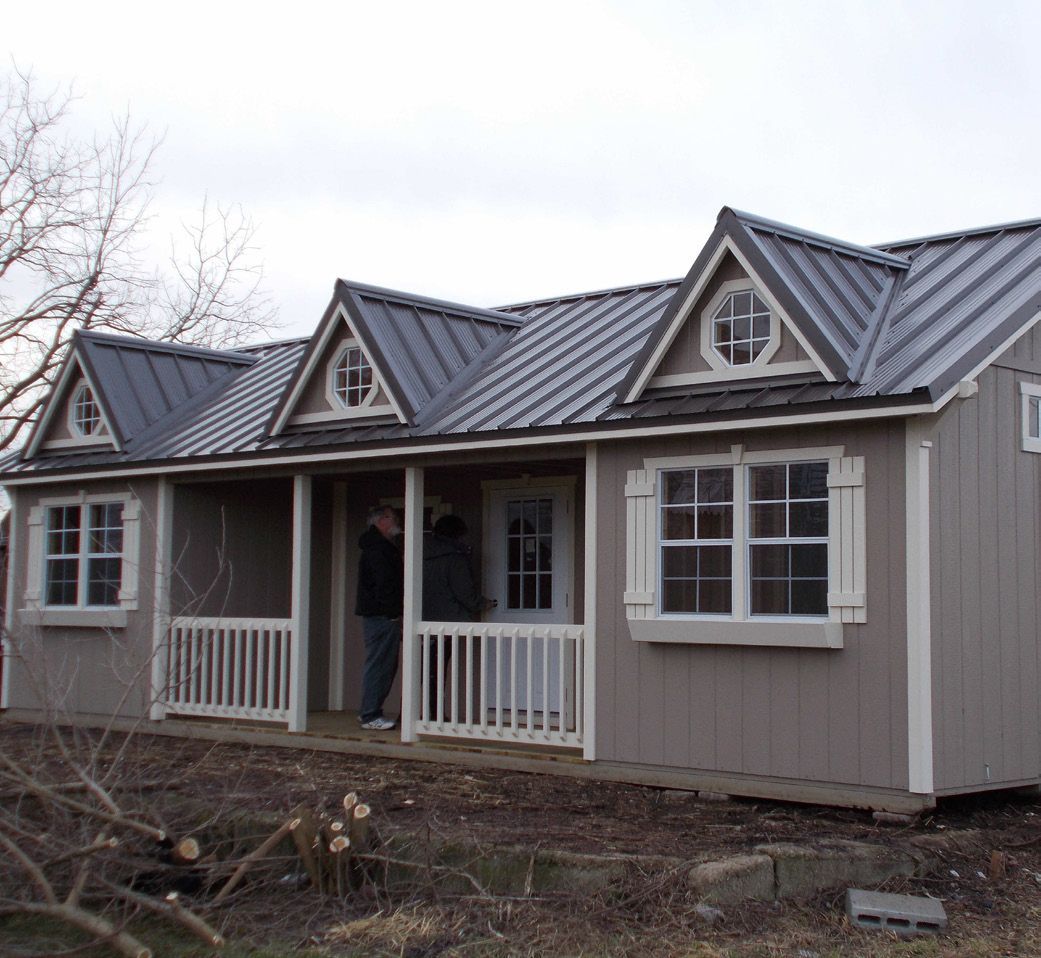 A small house with a metal roof and a porch