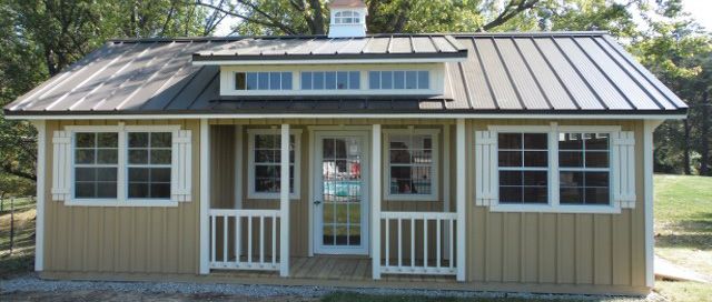 A small house with a metal roof and a porch