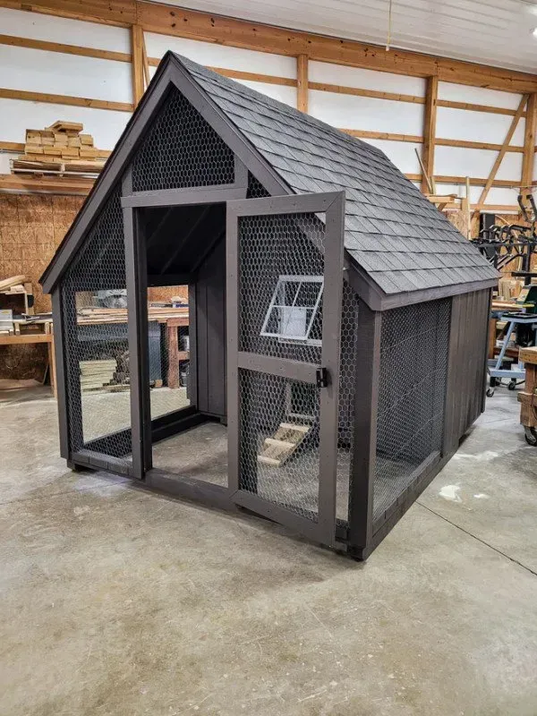 A chicken coop is sitting inside of a building.