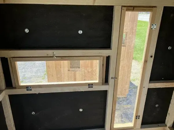A wooden wall with a window and a door