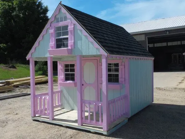 A pink and white playhouse with a porch